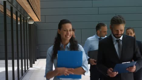 personas de negocios que interactúan entre sí mientras caminan por las instalaciones de la oficina