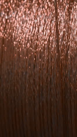 primer plano de un carrete de hilo de bordado de color cobre