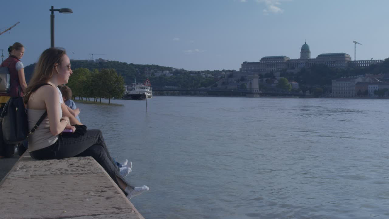Girls sitting on the pier infront of the flooded danube, Budapest 2024.