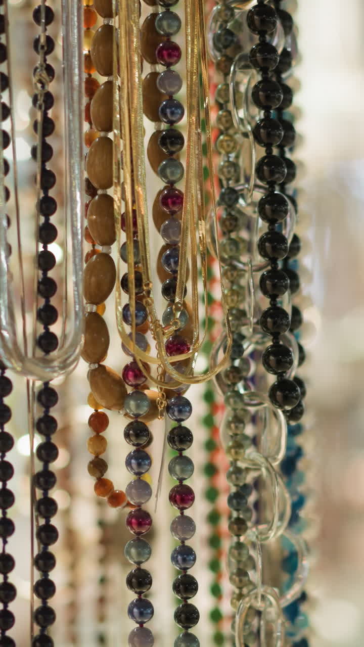 복잡한 디스플레이에 매달린 다채로운 구슬의 클로즈업 뷰, 구슬은 색, 크기 및 재료에 따라 다릅니다.