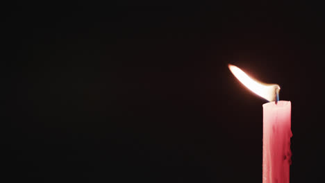 Video-of-red-candle-with-white-flame-and-copy-space-on-black-background