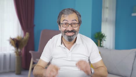 Low-vision-man-wearing-glasses-and-waving-smiling-at-camera.