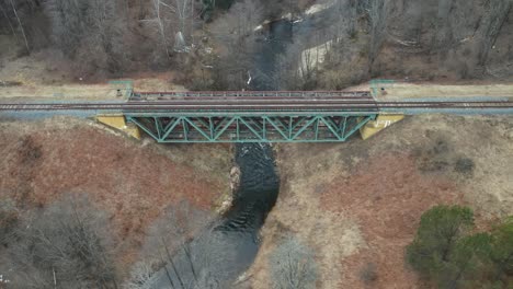 aerial: rail road bridge constructed over river in lithuania