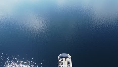 car and passenger ferry mf oppedal entering into frame from birdseye perspective - beautiful sunny day with calm sea connecting road e39 between oppedal and lavik - static aerial norway