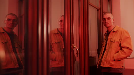 man in a yellow jacket, red lit room