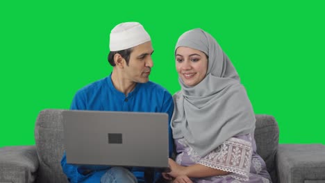 Happy-Muslim-couple-doing-online-shopping-on-laptop-Green-screen