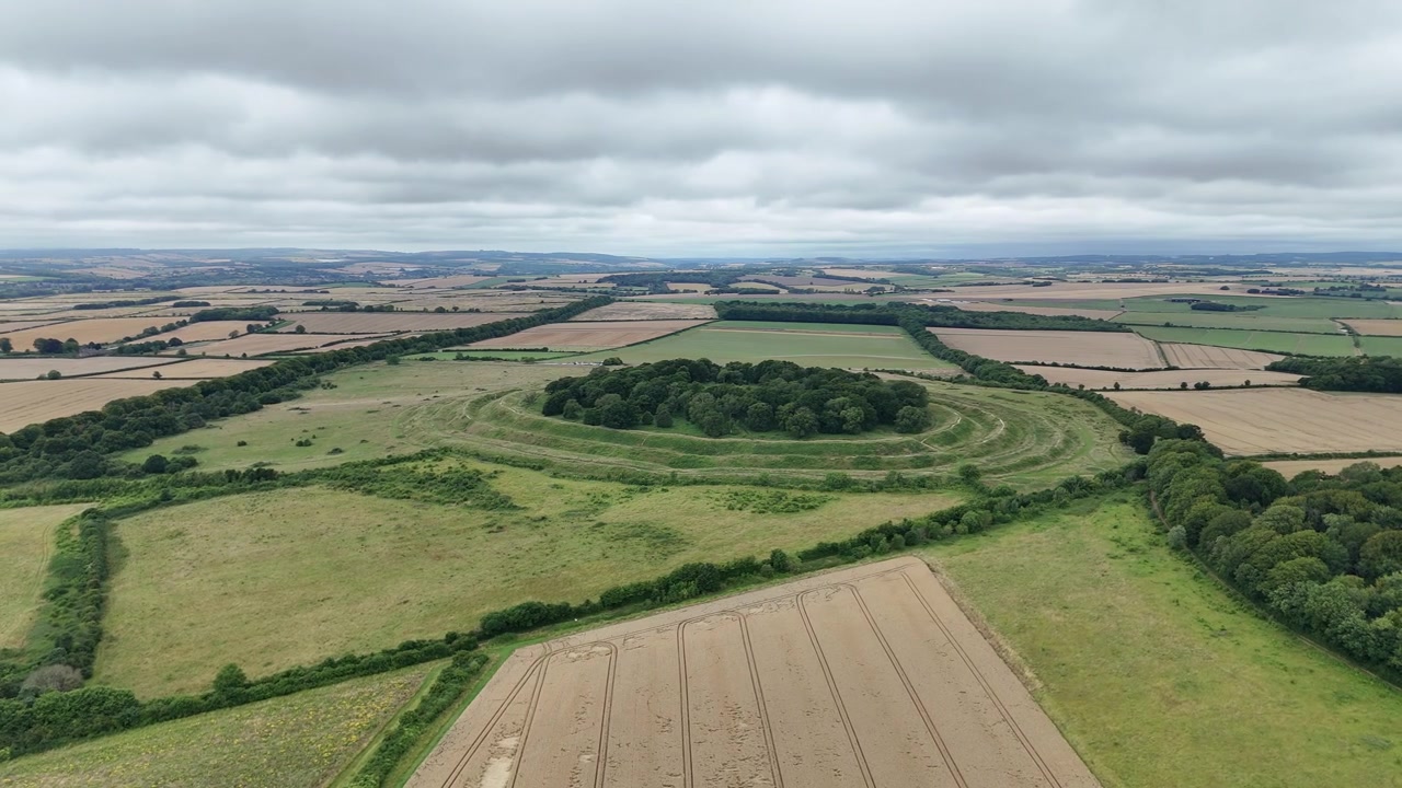 Luchtfoto cirkelend rond Badbury Rings Dorset, historisch ijzertijd Romeins heuvelfort platteland uitzichtpunt