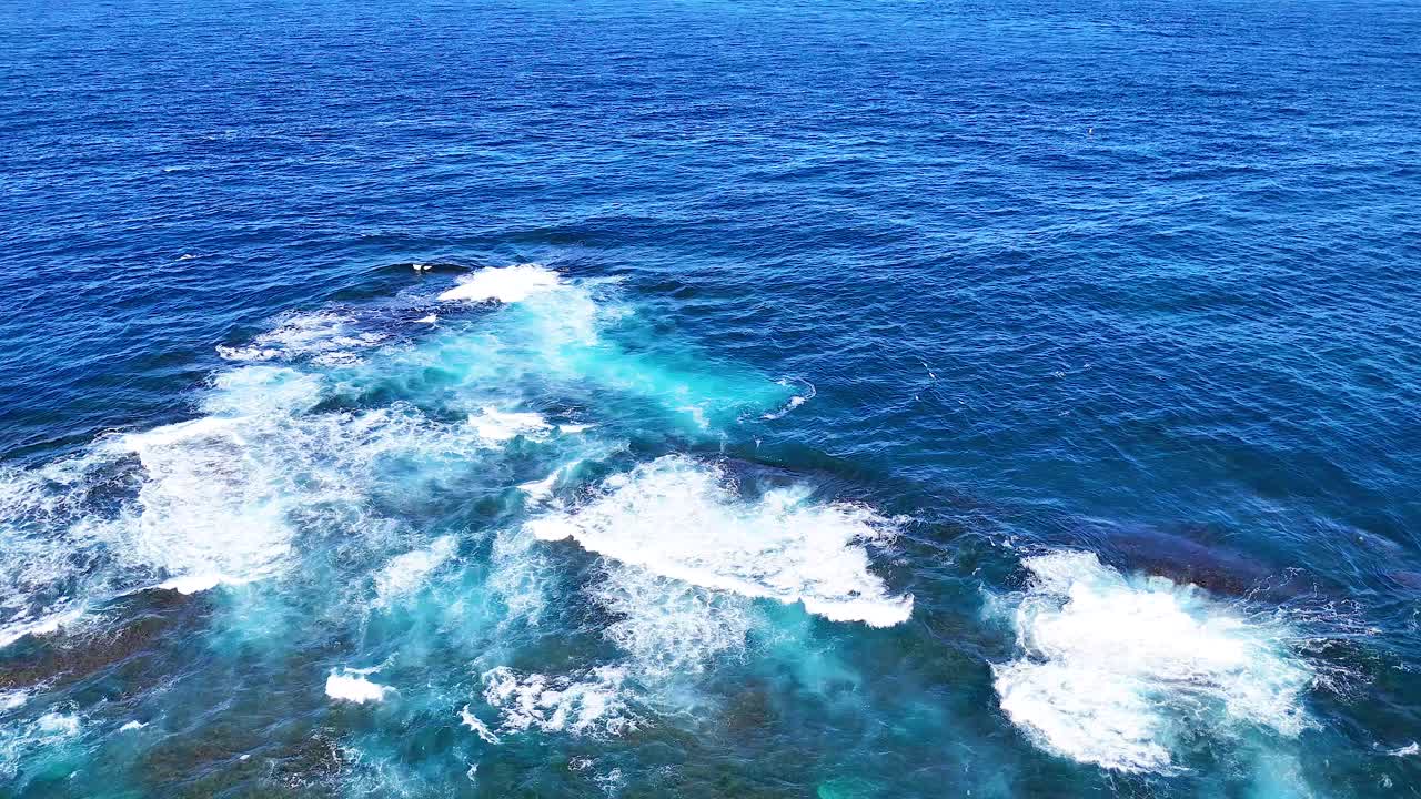 바위가 있는 해안선에서 바다의 파도가 부히고