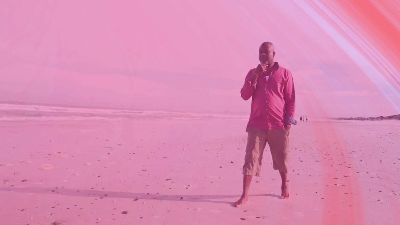 Senior man walking barefoot along beach, viewing animated finance graph rising above shoreline