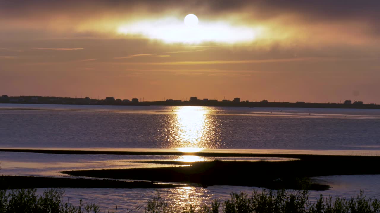 바다 표면에 보라색 반사가 있는 아름다운 주황색 바다 일몰