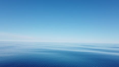 clear water with no waves on lake michigan, great lakes, no land in sight, cloudless day, clear skies