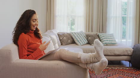 Happy-woman-sitting-on-sofa-using-her-mobile-phone-4K-4k