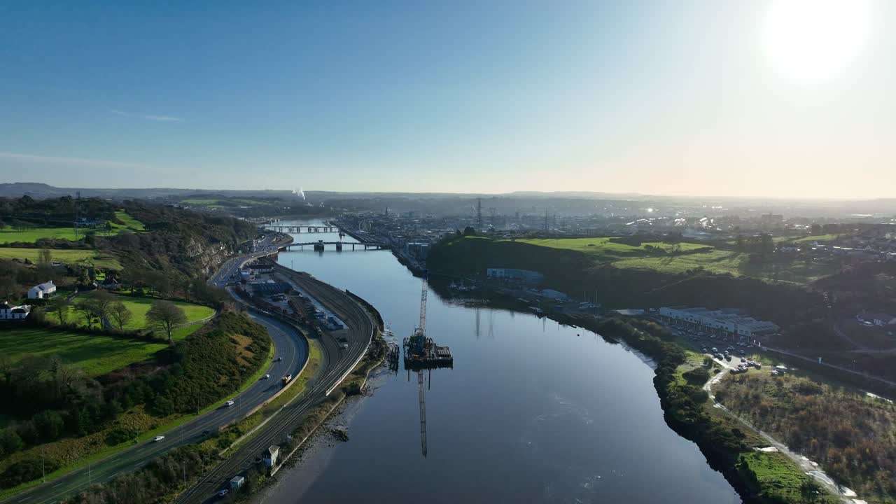 Waterford City drone view early morning cars on dual carriageway and barge on Suir River