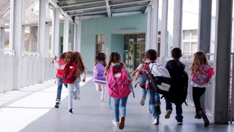 leerlingen van de basisschool rennen weg van de camera in de schoolcorridor.