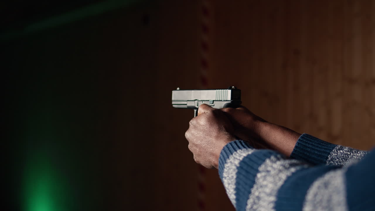 Shooting gallery client using handgun to hit paper targets with ammo, close up