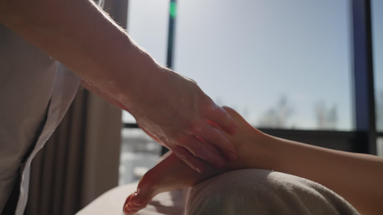 Närbild på professionella händer som ger en avslappnande fotmassage