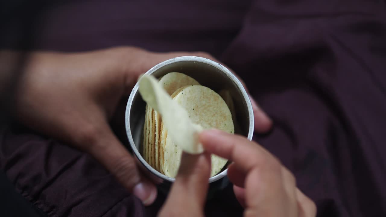 Close-up de Mãos Pegando Batatas Fritas de uma Lata