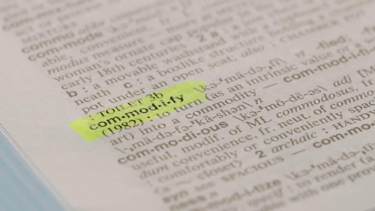 Commodify Business Dictionary Highlighter Concept, highlighting a word in a dictionary to show it's definition