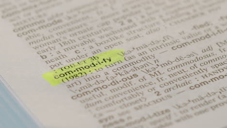Commodify Business Dictionary Highlighter Concept, highlighting a word in a dictionary to show it's definition