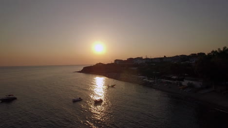 Escena-Del-Atardecer-Del-Resort-Y-El-Mar-Con-Barcos-En-La-Playa-Aérea-De-Trikorfo-En-Grecia