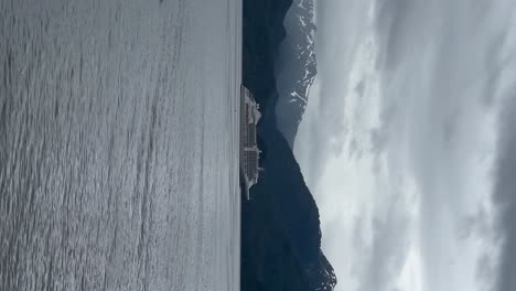 A-cruise-ship-anchored-across-from-the-port-of-Sitka,-Alaska---panning-vertical-view