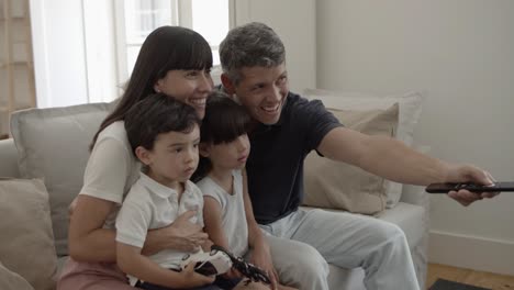 padres felices con dos hijos viendo su programa favorito