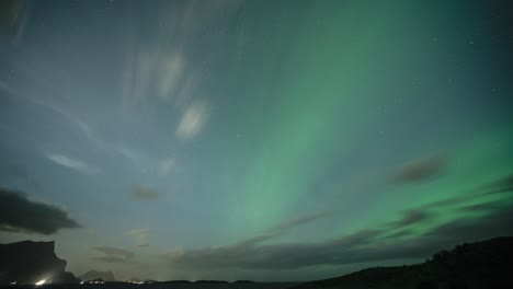 Wolken-Fliegen-In-Den-Dunklen-Nachthimmel,-Geschmückt-Mit-Dem-Hypnotisierenden-Tanz-Der-Nordlichter