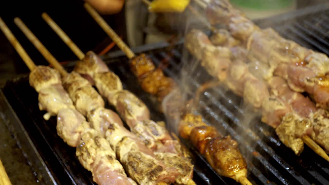 Grillattuja vartaita Cholula-festivaaleilla, liekkien leimahtaessa katuruokaa kypsennettäessä.
