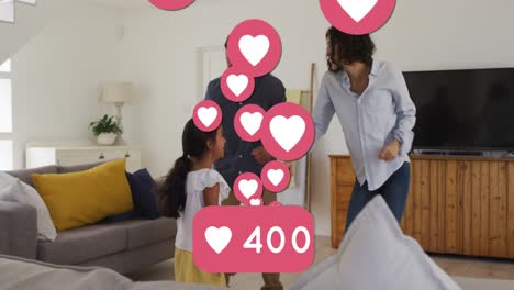 Animation-of-social-media-heart-icons-and-numbers-over-biracial-parents-and-daughter-dancing