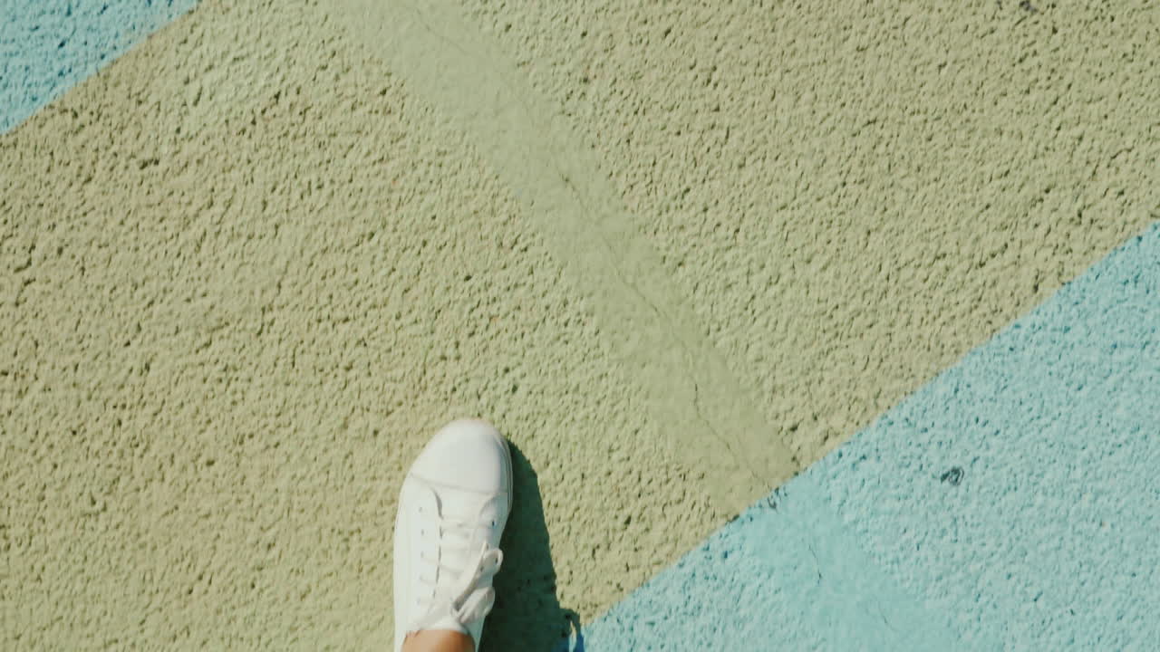 운동화를 신은 다리가 줄무늬 경기장 덮개를 밟다