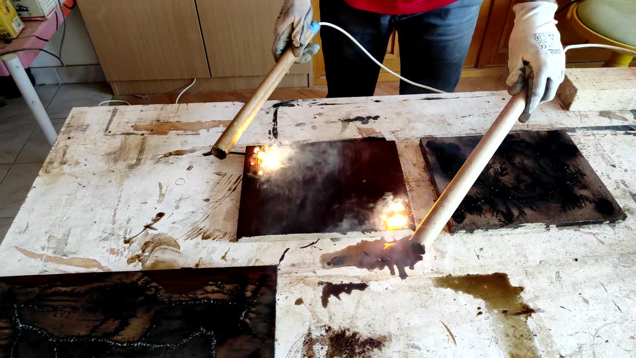 Nærbillede af træudbrænding med højspændingselektricitet og flammer, der skaber flodlignende mønstre i træet