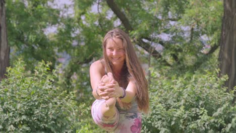hermosa mujer sonriendo y haciendo yoga al aire libre en un día soleado
