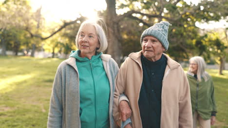 Senior-couple,-walking-and-talking-in-park