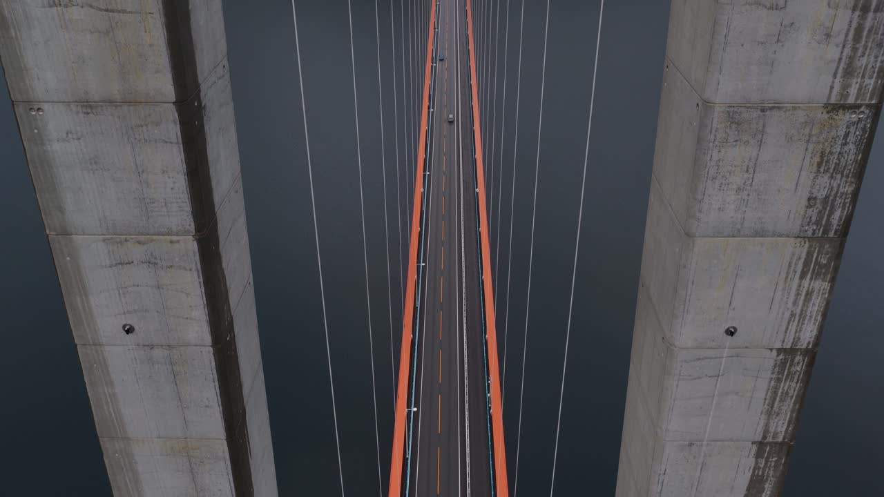 Cloudy aerial clip of Hardanger Bridge traffic above Norwegian fjord