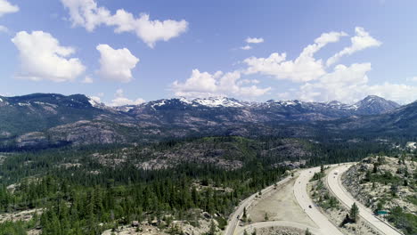 dolly forward showing highway next to forest and revealing more mountains with ice