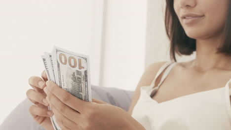 woman counting hundred dollar bills