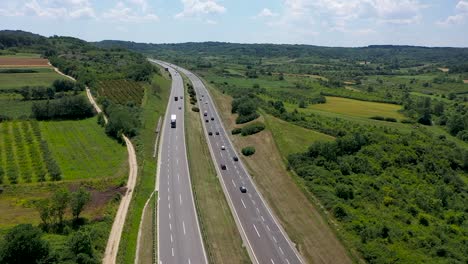 drone shot of highway with green surroundings