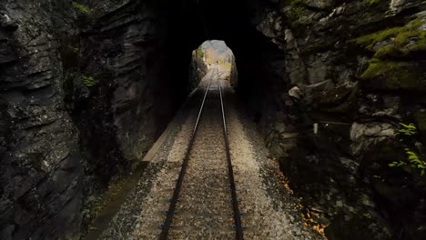 paso lento a través de un túnel ferroviario, con las vías separándose a la salida