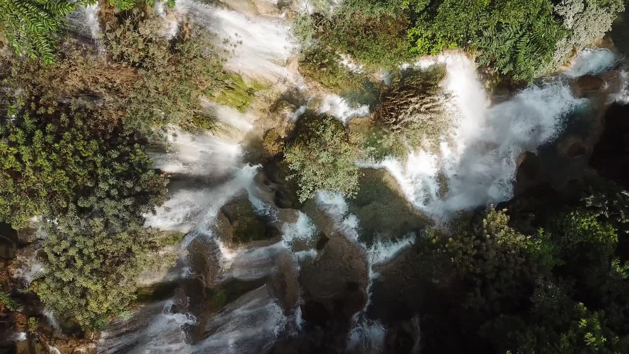 increíble vista aérea de arriba hacia abajo en la cascada kuang si bañada por la luz del sol