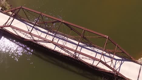 vuelo aéreo sobre el viejo puente de acero en el río