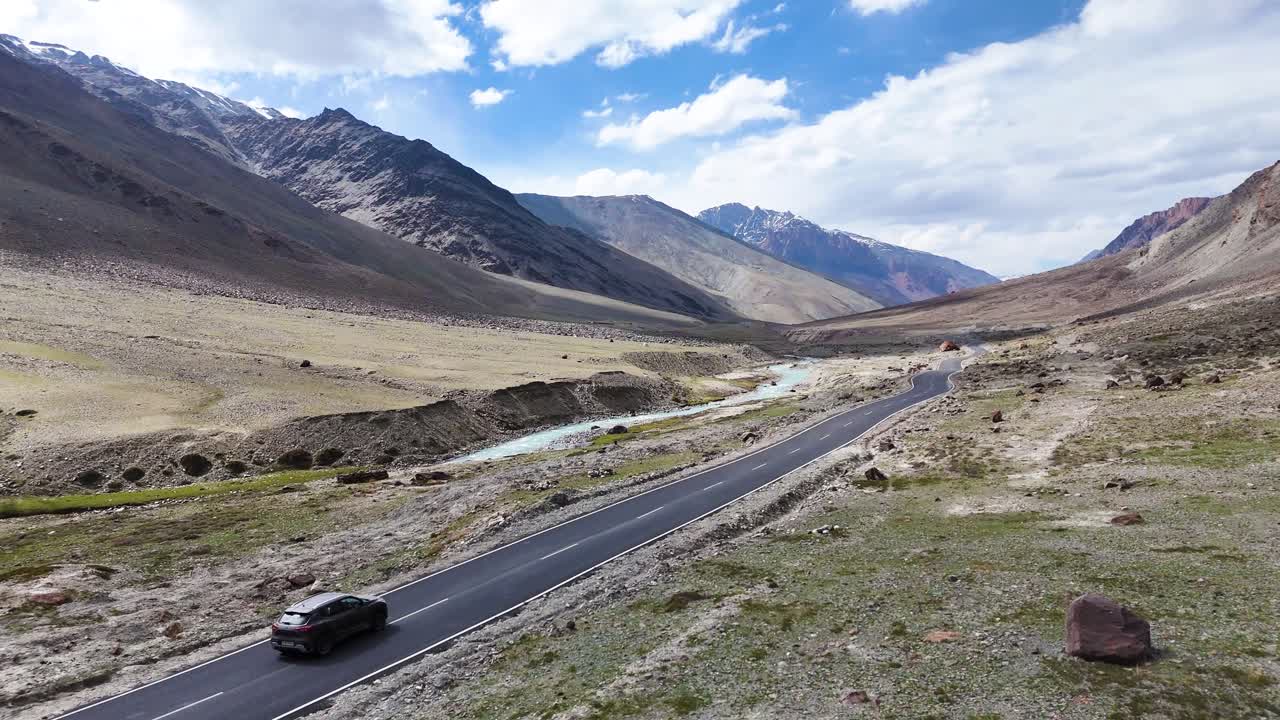 Aerial drone shot showcasing Gumbok Rangan’s towering summit framed by dramatic mountain ranges.