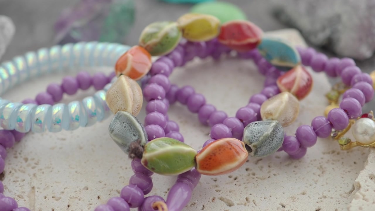 Collection of Colorful Beaded Bracelets on Textured Stone Surface
