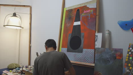 artist painting a large oil piece in his studio