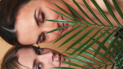 two women behind a palm leaf