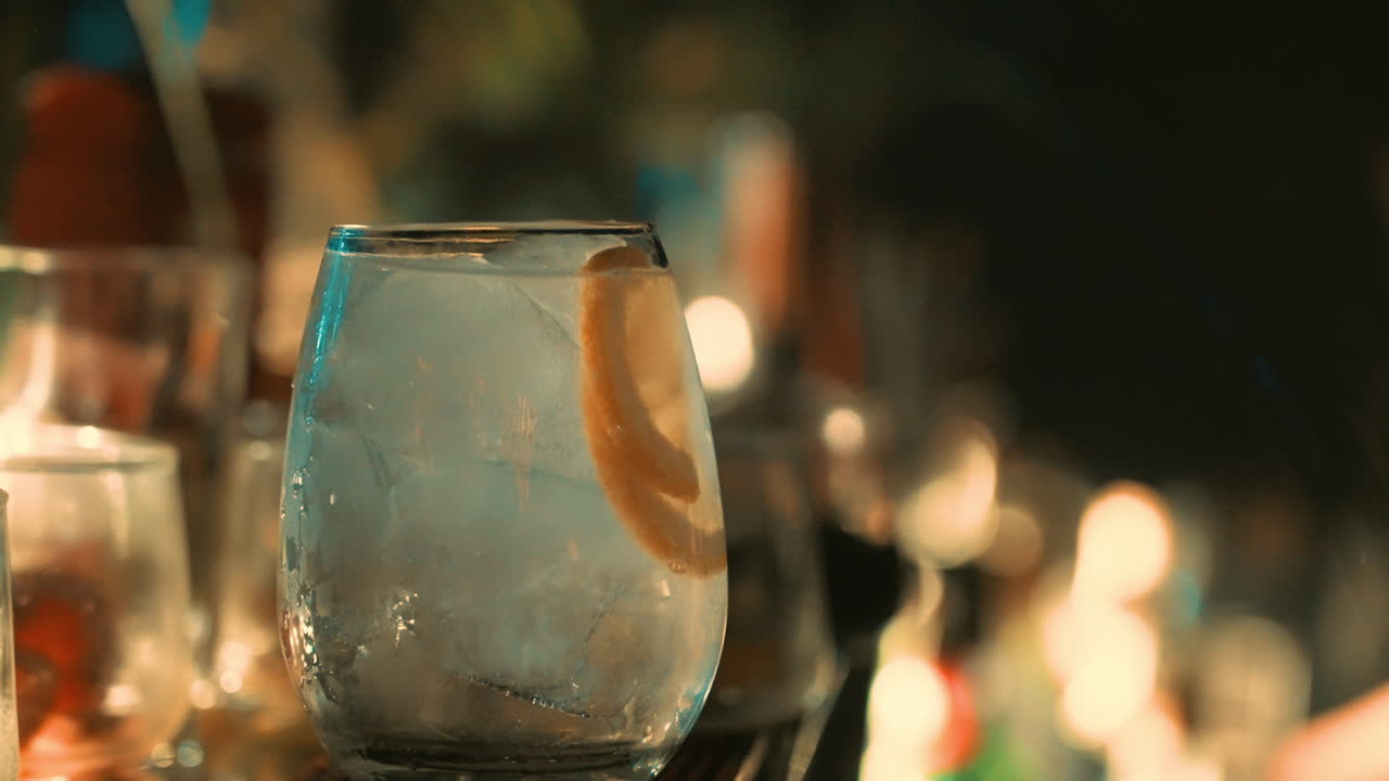 Primo piano di una mano che guarnisce un cocktail con scorza di limone.