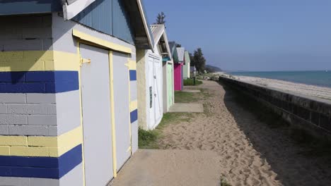 colorful beach boxes along a sandy path