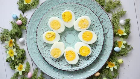 Easter-table-setting-with-flowers-and-eggs--Decorative-plates-with-boiled-eggs