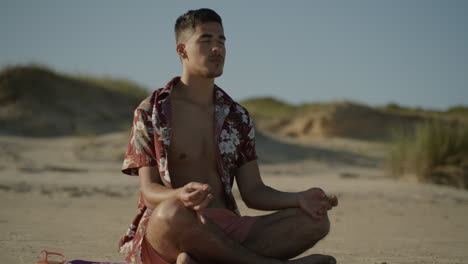 joven meditando en la playa