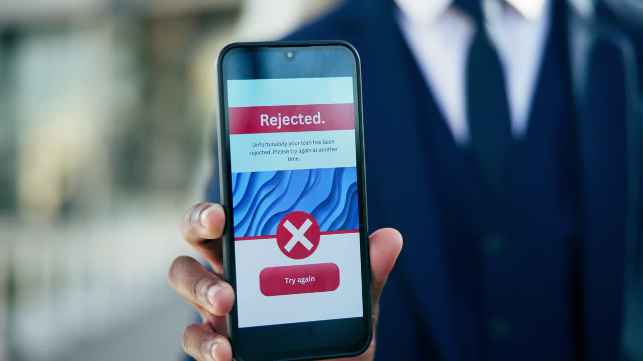 Man Holding Phone Showing Rejected Loan Application