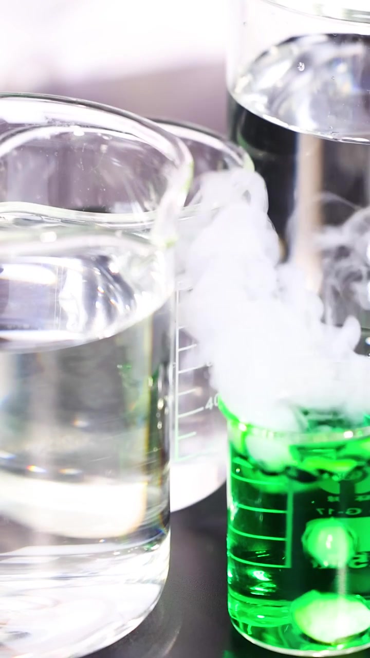 Liquide vert réagissant et émettant de la vapeur dans des béchers